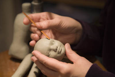 Maggie scupting a doll's face